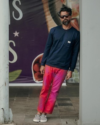 Blue Sweatshirt Outfits For Men: If you're searching for a casual yet stylish ensemble, dress in a blue sweatshirt and hot pink tie-dye chinos. Finish off with a pair of black and white check canvas slip-on sneakers and you're all set looking amazing.