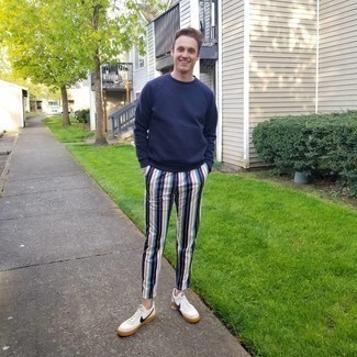 White and Navy Vertical Striped Chinos Outfits: This pairing of a navy sweatshirt and white and navy vertical striped chinos is extremely easy to imitate and so comfortable to wear a variation of as well! Complement this look with white and navy leather low top sneakers for extra style points.