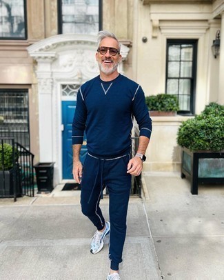 66 Relaxed Summer Outfits For Men: Reach for a navy track suit, if you prefer to dress for comfort without looking like a slob to look dapper. Let your styling sensibilities truly shine by finishing this look with a pair of light blue athletic shoes. A neat look like this one is just what you need come baking hot summer days.