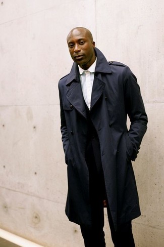 Navy Trenchcoat Outfits For Men: One of the smartest ways to style such a timeless menswear piece as a navy trenchcoat is to marry it with a black suit.