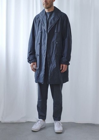Navy Trenchcoat Outfits For Men: A navy trenchcoat and charcoal chinos are absolute mainstays if you're crafting a classy closet that holds to the highest style standards. You can take a more laid-back approach with shoes and complete your outfit with white canvas low top sneakers.
