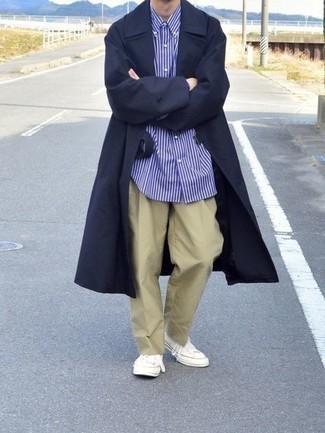 Navy Trenchcoat Outfits For Men: This combo of a navy trenchcoat and khaki chinos is ideal for dressier situations. Serve a little outfit-mixing magic by sporting white canvas low top sneakers.