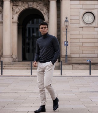 Black Leather Chelsea Boots Outfits For Men: Team a navy turtleneck with white chinos if you wish to look casual and cool without too much work. Not sure how to complement this getup? Rock black leather chelsea boots to spruce it up.