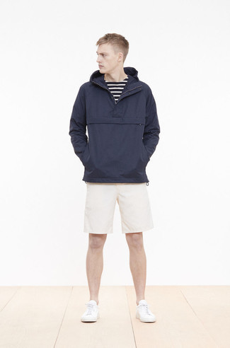 Beige Shorts Outfits For Men: Exhibit your prowess in menswear styling by pairing a navy windbreaker and beige shorts for a laid-back combination. Let your expert styling really shine by finishing off this outfit with white canvas low top sneakers.