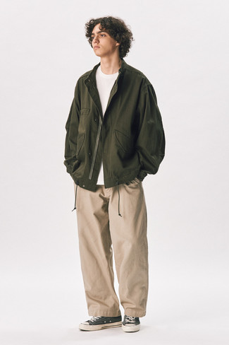 Olive Bomber Jacket Outfits For Men: This relaxed combo of an olive bomber jacket and khaki chinos can only be described as devastatingly dapper. Take an otherwise mostly classic look down a more laid-back path by rocking charcoal canvas low top sneakers.