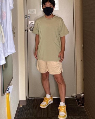 Mustard Low Top Sneakers Outfits For Men: Reach for an olive crew-neck t-shirt and beige sports shorts for both stylish and easy-to-create look. Elevate this outfit with mustard low top sneakers.