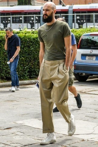 Khaki Dress Pants Outfits For Men: If the dress code calls for a casually classic getup, make an olive crew-neck t-shirt and khaki dress pants your outfit choice. White canvas high top sneakers will add a more laid-back finish to an otherwise classic look.