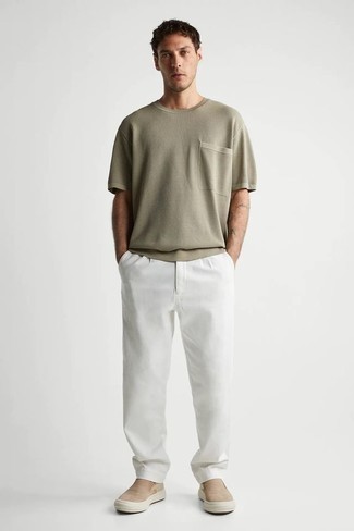 White Chinos Outfits: This combo of an olive crew-neck t-shirt and white chinos will prove your prowess in men's fashion even on weekend days. When not sure about what to wear in the shoe department, stick to tan canvas slip-on sneakers.