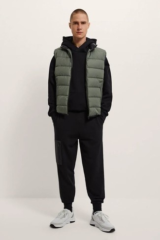 Olive Quilted Gilet Outfits For Men: If the situation permits a casual ensemble, pair an olive quilted gilet with a black track suit. Introduce white athletic shoes to your ensemble et voila, this look is complete.
