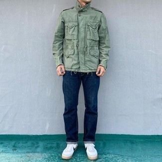 Military Jacket Outfits For Men: Display your chops in menswear styling by combining a military jacket and navy jeans for a relaxed casual outfit. White and navy canvas low top sneakers can easily dress down an all-too-polished ensemble.