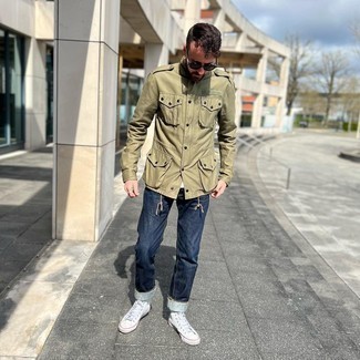 Military Jacket Outfits For Men: This casual combination of a military jacket and navy jeans is capable of taking on different moods according to how you style it. Put a modern spin on this ensemble by finishing off with a pair of white canvas high top sneakers.