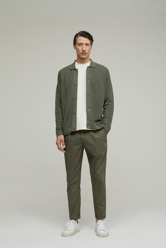 Olive Cardigan Warm Weather Outfits For Men: An olive cardigan and olive chinos combined together are a sartorial dream for men who love sophisticated combinations. A pair of white canvas low top sneakers immediately kicks up the appeal of this look.