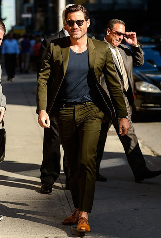 Dark Green Suit Outfits: This semi-casual combination of a dark green suit and a charcoal crew-neck t-shirt is capable of taking on different moods according to the way you style it out. With shoes, you can take a classier route with tan leather oxford shoes.