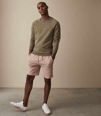 Hot Pink Shorts Outfits For Men: For a look that's very simple but can be worn in a great deal of different ways, marry an olive sweatshirt with hot pink shorts. Complement your ensemble with white canvas low top sneakers and you're all set looking incredible.