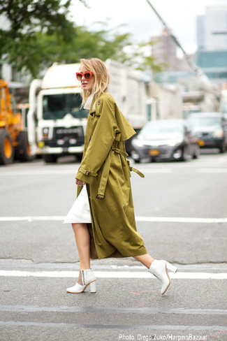 Olive Trenchcoat Outfits For Women: Marry an olive trenchcoat with a white midi dress to assemble a proper and polished ensemble. White leather ankle boots look amazing here.