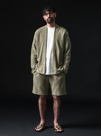 Men's Outfits 2022: For a look that's pared-down but can be worn in a multitude of different ways, team an olive fleece open cardigan with olive sports shorts. Add a pair of beige canvas sandals to the mix to keep the ensemble fresh.
