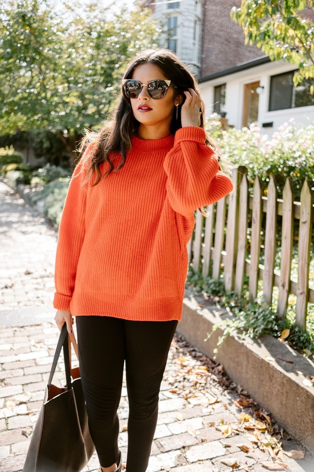 Women's Orange Knit Cable Sweater, Black Leggings, Black Leather Tote Bag,  Black Sunglasses | Lookastic