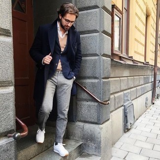 Tan Sweater Vest Outfits For Men: You'll be amazed at how very easy it is to put together this elegant outfit. Just a tan sweater vest paired with grey wool dress pants. Get a bit experimental in the footwear department and dress down this look by rocking white athletic shoes.