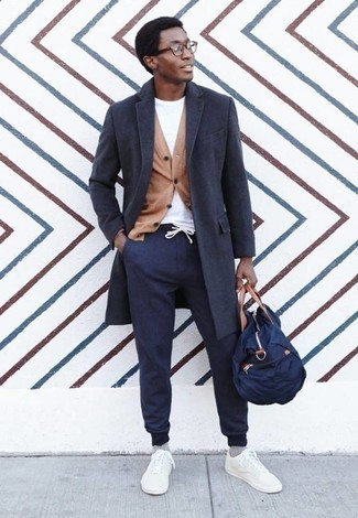 Navy Sweatpants Cold Weather Outfits For Men: A charcoal overcoat and navy sweatpants are the kind of a winning off-duty ensemble that you so terribly need when you have zero time to spare. Add white canvas low top sneakers to this getup to avoid looking too polished.