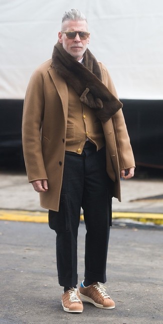 This combination of a camel overcoat and black wool cargo pants is undoubtedly a statement-maker. Here's how to give a more relaxed vibe to this getup: tan low top sneakers.