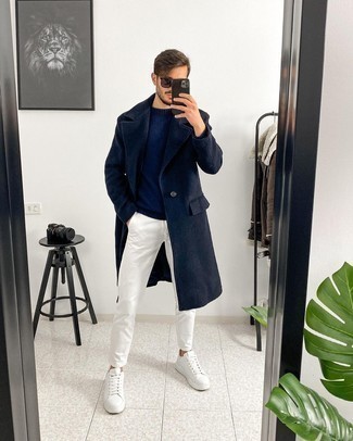 Navy Crew-neck Sweater with White Leather Low Top Sneakers Outfits For Men: Go for a pared down but at the same time neat and relaxed getup in a navy crew-neck sweater and white chinos. Add white leather low top sneakers to your look to instantly kick up the wow factor of your getup.