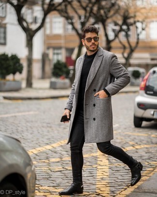 Black Leather Chelsea Boots Outfits For Men: A grey herringbone overcoat and black skinny jeans married together are a sartorial dream for those dressers who prefer laid-back and cool styles. Go ahead and complement this outfit with black leather chelsea boots for a dose of refinement.