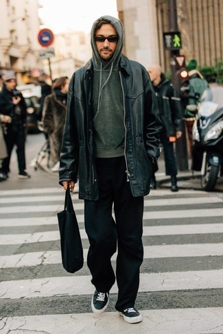 Black Canvas Tote Bag Outfits For Men: Try teaming a black leather overcoat with a black canvas tote bag for a trendy and modern casual ensemble. This getup is complemented really well with black and white canvas low top sneakers.