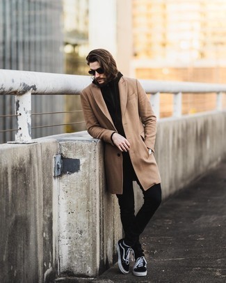 Black Skinny Jeans Outfits For Men: Wear a camel overcoat with black skinny jeans for relaxed dressing with a modern twist. Black and white canvas low top sneakers are guaranteed to bring a sense of stylish casualness to this ensemble.