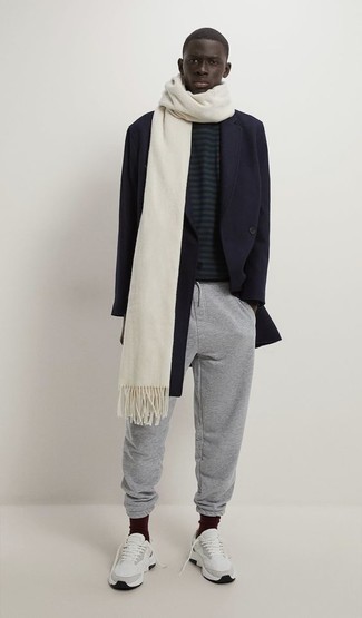 White Scarf Outfits For Men: Pairing a navy overcoat with a white scarf is an awesome idea for a casual but sharp outfit. Feeling bold? Break up your look by wearing a pair of white athletic shoes.
