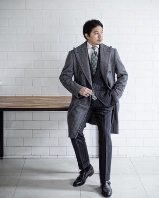 500+ Chill Weather Outfits For Men: A grey herringbone overcoat and a black vertical striped suit are an elegant ensemble that every modern gent should have in his collection. A pair of black leather monks will be the perfect complement to this look.