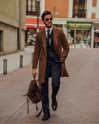 Backpack Outfits For Men: You can look stylish without trying too hard by opting for a brown overcoat and a backpack. To give your overall getup a classier touch, introduce a pair of dark brown leather derby shoes to the equation.