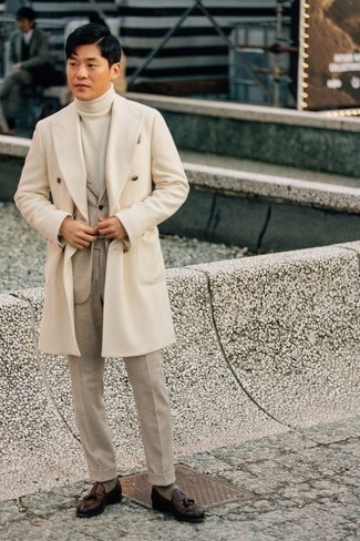 Beige Coat Outfits For Men: Marrying a beige coat and a beige suit is a surefire way to infuse your wardrobe with some masculine elegance. You can get a bit experimental when it comes to footwear and complement this outfit with a pair of dark brown leather tassel loafers.
