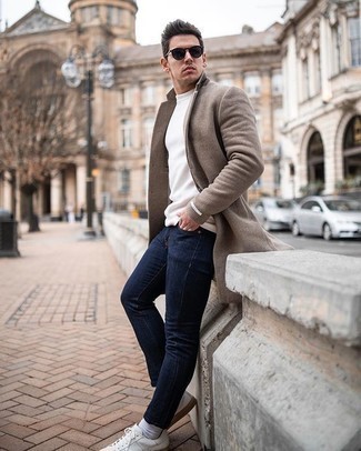 Brown Coat Outfits For Men: You're looking at the definitive proof that a brown coat and navy jeans look awesome when matched together. You can get a little creative when it comes to footwear and complete this outfit with white canvas low top sneakers.