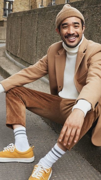 Dark Brown Corduroy Chinos Outfits: Make a camel overcoat and dark brown corduroy chinos your outfit choice to create a casually smart and well-executed outfit. For something more on the daring side to complement your look, add a pair of mustard canvas low top sneakers to this outfit.