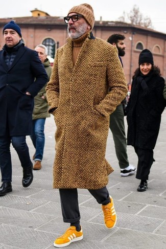 Mustard Suede Low Top Sneakers Outfits For Men: Definitive proof that a brown herringbone overcoat and black dress pants look amazing when worn together in a sophisticated ensemble for a modern gent. Introduce a pair of mustard suede low top sneakers to the equation to keep the look fresh.