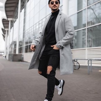 White and Black Canvas Low Top Sneakers Outfits For Men: This combination of a grey overcoat and black ripped jeans is pulled together and yet it looks easy enough and apt for anything. Add white and black canvas low top sneakers to this outfit and ta-da: this outfit is complete.