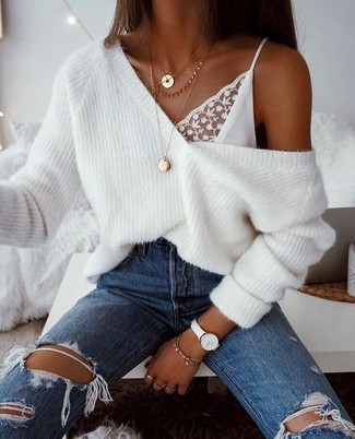 White Knit Oversized Sweater Relaxed Outfits: A white knit oversized sweater and blue ripped jeans are a combo that every cool girl should have in her casual sartorial arsenal.