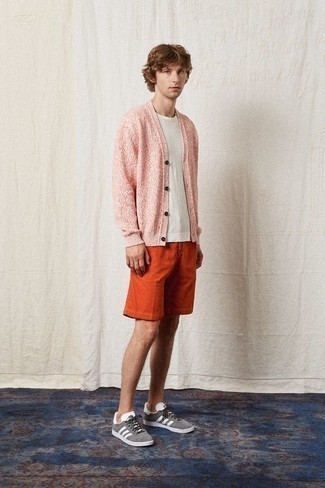 Pink Cardigan Outfits For Men: A pink cardigan and orange shorts are a great go-to combo to keep in your wardrobe. If you want to break out of the mold a little, complement this look with a pair of grey suede low top sneakers.