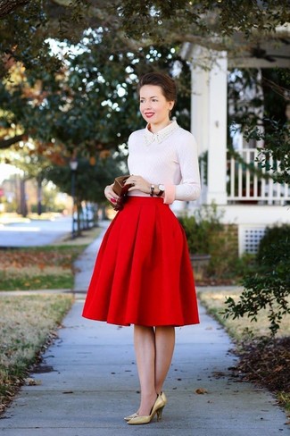 The combination of a pink crew-neck sweater and a red full skirt makes this a knockout relaxed casual ensemble. Puzzled as to how to round off? Add a pair of gold leather pumps to this ensemble to up the style factor.