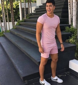 Hot Pink Crew-neck T-shirt Outfits For Men: This cool and casual look is really pared down: a hot pink crew-neck t-shirt and pink shorts. Complete this getup with white leather low top sneakers and ta-da: the ensemble is complete.