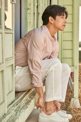 Pink Vertical Striped Long Sleeve Shirt Outfits For Men: The pairing of a pink vertical striped long sleeve shirt and white chinos makes this a neat off-duty getup. When it comes to shoes, add white leather low top sneakers to the equation.