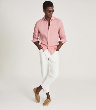 Premium Photo | A man in a pink shirt and white pants stands against a blue  wall.