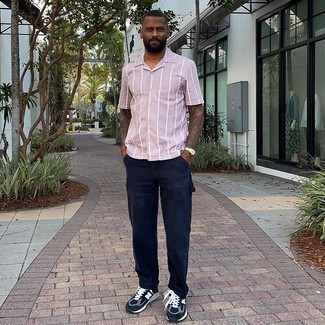 Pink Vertical Striped Short Sleeve Shirt Outfits For Men: If you're on a mission for a laid-back but also stylish outfit, pair a pink vertical striped short sleeve shirt with navy chinos. Bring a mellow touch to this look by slipping into a pair of navy and white athletic shoes.