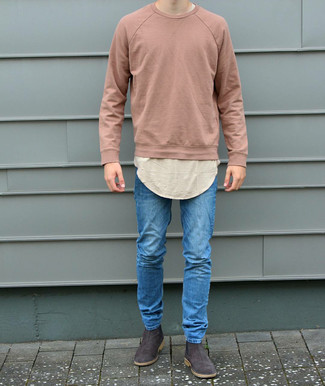 Pink Sweatshirt Outfits For Men: This relaxed casual combo of a pink sweatshirt and blue skinny jeans is a winning option when you need to look dapper but have no time to spare. For a dressier aesthetic, why not complement your look with a pair of dark brown suede chelsea boots?