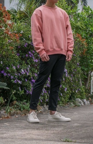 Pink Sweatshirt Outfits For Men: A pink sweatshirt and charcoal chinos are indispensable menswear must-haves to have in the casual part of your wardrobe. Let your sartorial skills truly shine by finishing off this look with white canvas low top sneakers.
