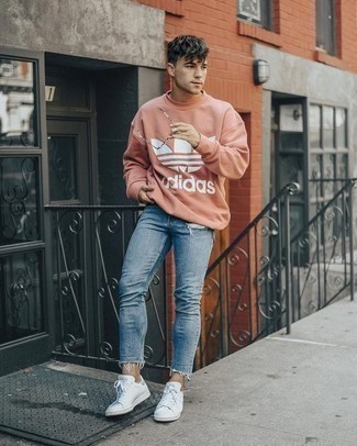 Pink Sweatshirt Outfits For Men: If you’re a jeans-and-a-tee kind of guy, you'll like this straightforward but cool and casual pairing of a pink sweatshirt and light blue ripped skinny jeans. Go ahead and complete your look with a pair of white leather low top sneakers for a hint of elegance.