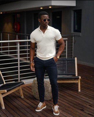 Brown Leather Low Top Sneakers Outfits For Men: This combo of a white polo and navy chinos is the ultimate laid-back getup for any modern gentleman. The whole look comes together really well when you introduce brown leather low top sneakers to the equation.