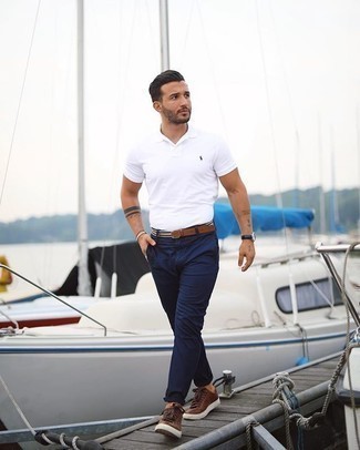 White and Navy Horizontal Striped Canvas Belt Outfits For Men: Make a white polo and a white and navy horizontal striped canvas belt your outfit choice to assemble an interesting and city casual outfit. Brown leather low top sneakers will take your getup down a whole other path.