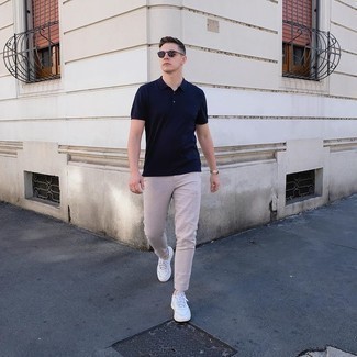 Navy Polo Outfits For Men: If you're facing a sartorial situation where comfort is essential, this combination of a navy polo and beige chinos is always a winner. All you need is a pair of white leather low top sneakers to round off your look.