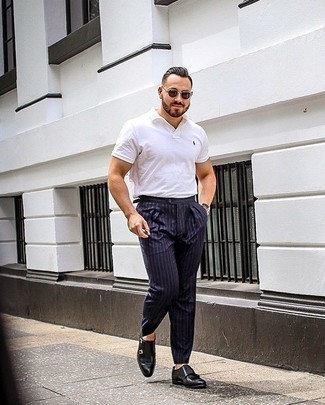 Navy and White Vertical Striped Dress Pants Outfits For Men: For a never-failing classic and casual option, you can't go wrong with this combo of a white polo and navy and white vertical striped dress pants. Serve a little mix-and-match magic by finishing with black leather double monks.